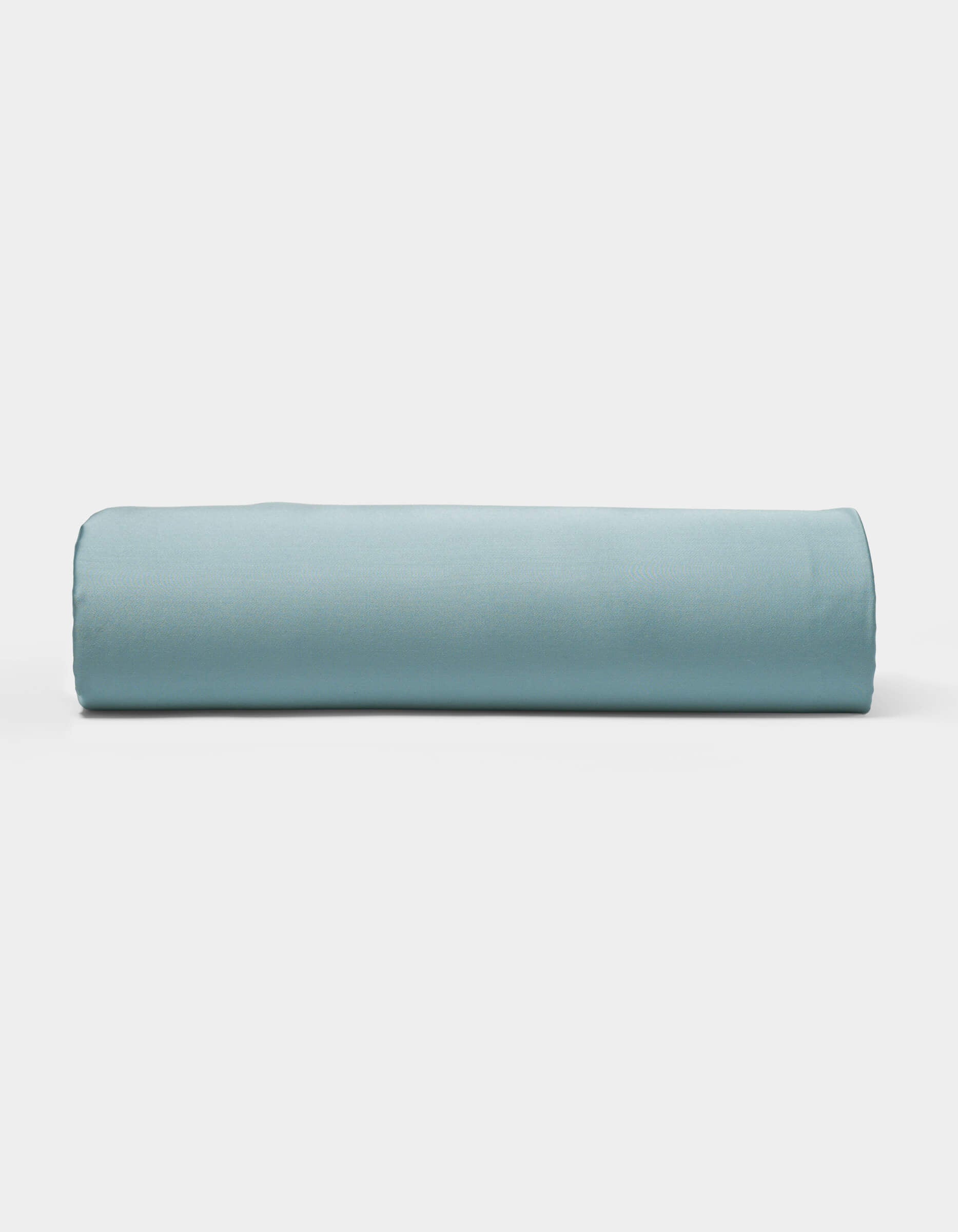 A neatly rolled light blue Bamboo Sheet Set by Cozy Earth is displayed on a plain white background.|Color:River