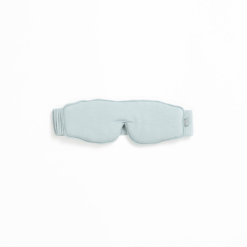 A light gray sleep mask from the Rest & Reset Bundle by Cozy Earth, featuring an adjustable strap, displayed on a white background.