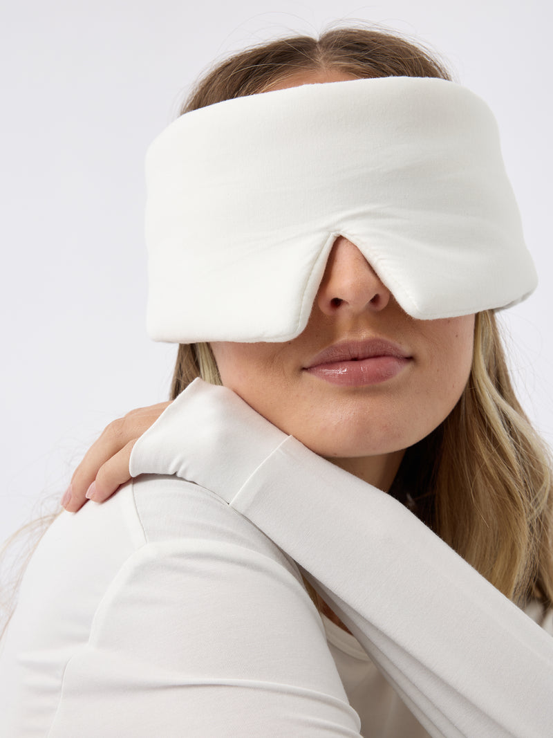 A woman wears the Cozy Earth Adjustable Bamboo Sleep Mask in Ivory.