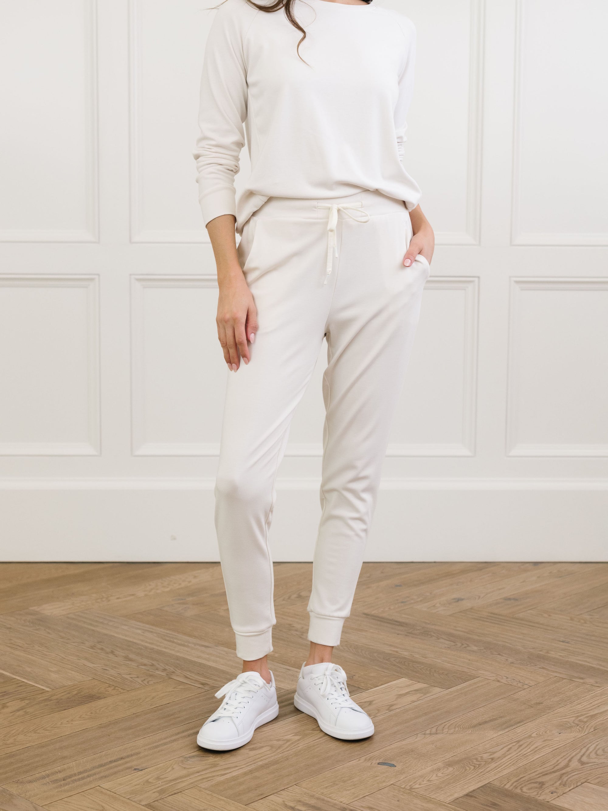 Ivory Bamboo Jogger Set modeled by a woman. The photo was taken in a high contrast setting, showing off the colors and lines of the pajamas. 