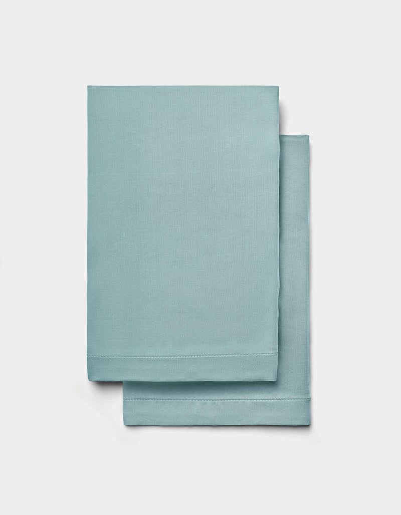 Two neatly folded Cozy Earth Bamboo Sheet Set sheets are stacked on top of each other against a plain white background.