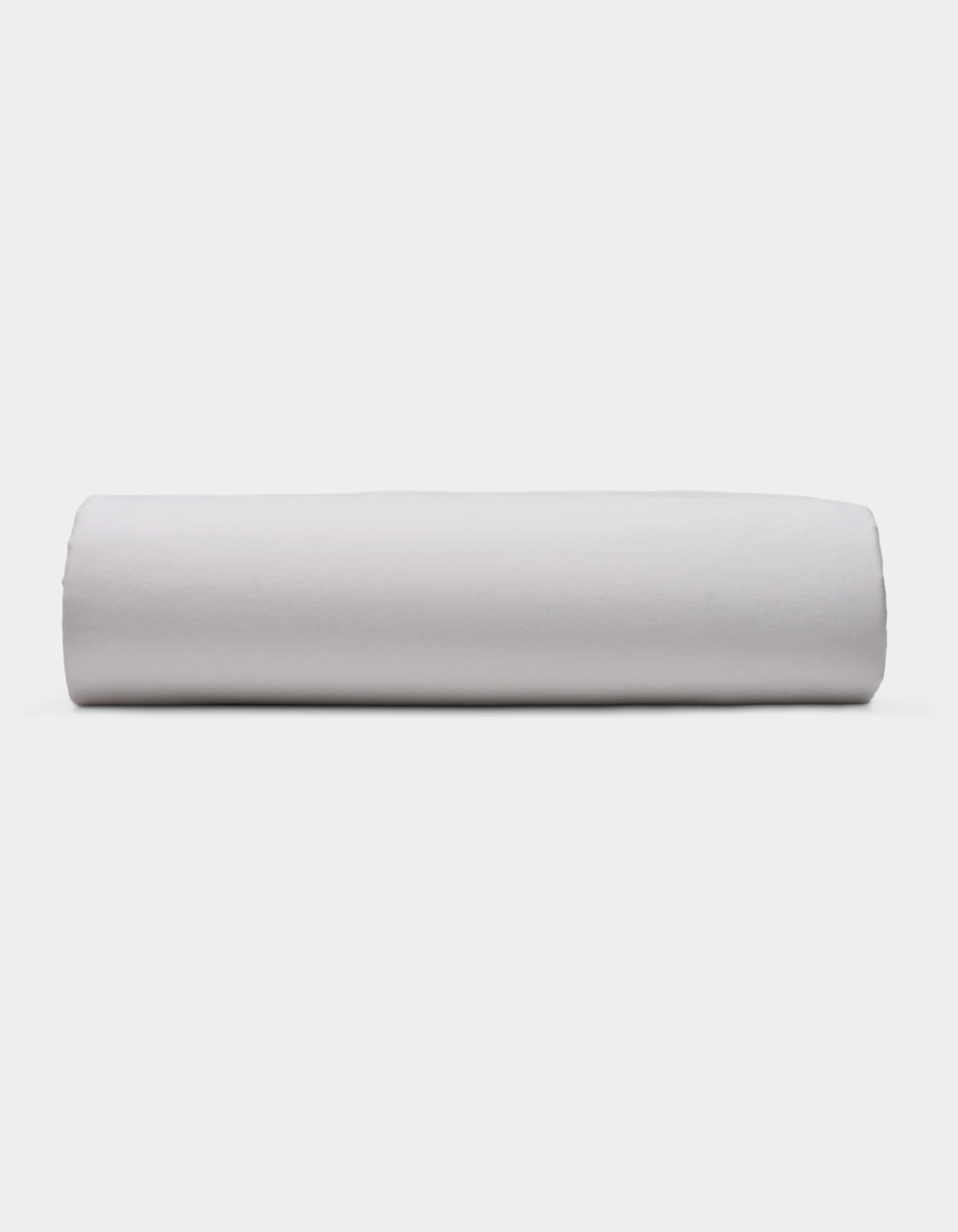 A Soft-Wash Cotton Fitted Sheet by Cozy Earth is displayed lying flat on a light surface with a neutral background.
