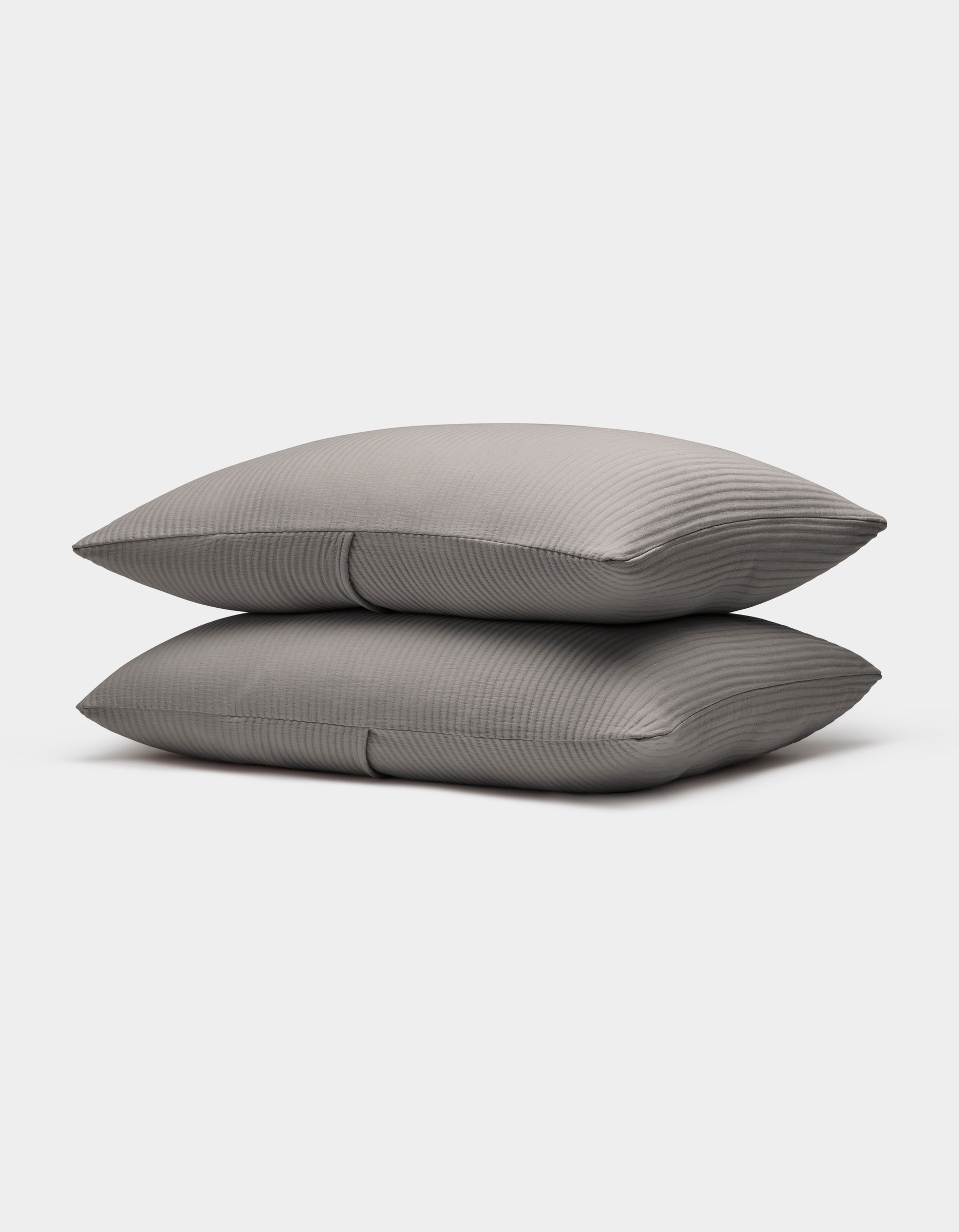 Two neatly stacked Bamboo Coverlet Shams by Cozy Earth in gray with stripes, displayed on a plain white background.