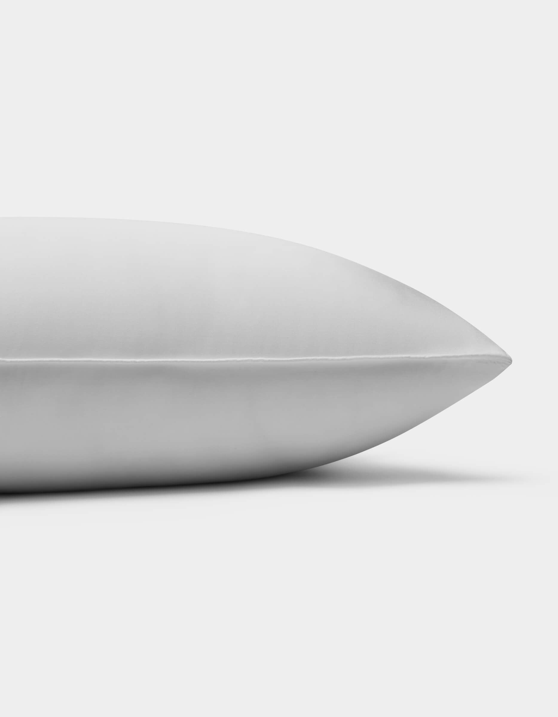 A close-up side view of the Cozy Earth Bamboo Insert Bundle pillow on a plain white background, highlighting its smooth surface and clean seam.
