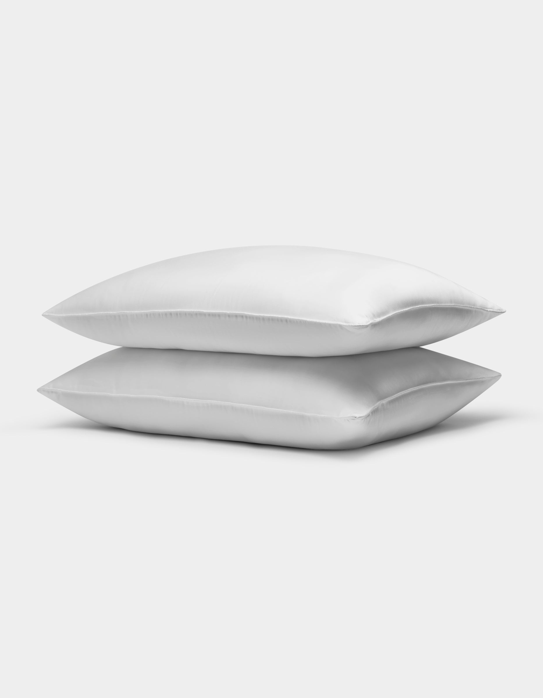 Two Cozy Earth Bamboo Down Alternative Pillows are stacked neatly against a plain white background. Charcoal, Driftwood, Oat, Creme, White, Dove Grey, Light Grey, Shore, Pacific Blue, Peony, Walnut, Classic Stripe in Pacific, Classic Stripe in Ebony, Classic Stripe in Laurel, Mulberry, River