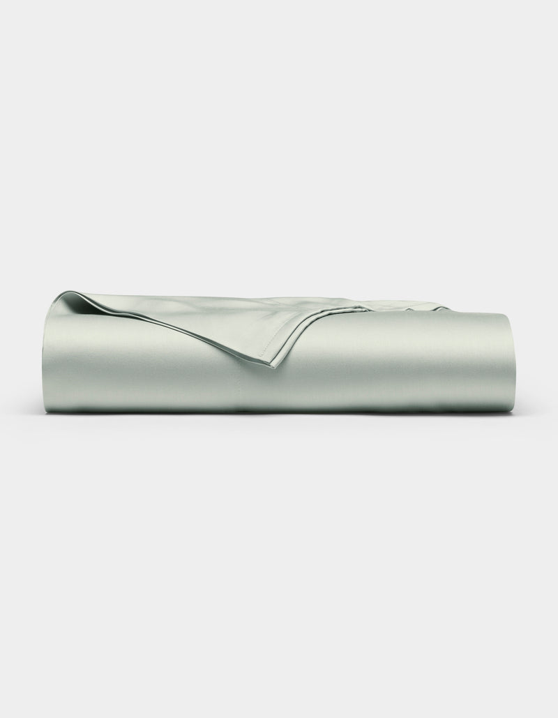 A neatly folded Bamboo Flat Sheet by Cozy Earth in light gray is displayed against a plain white background.