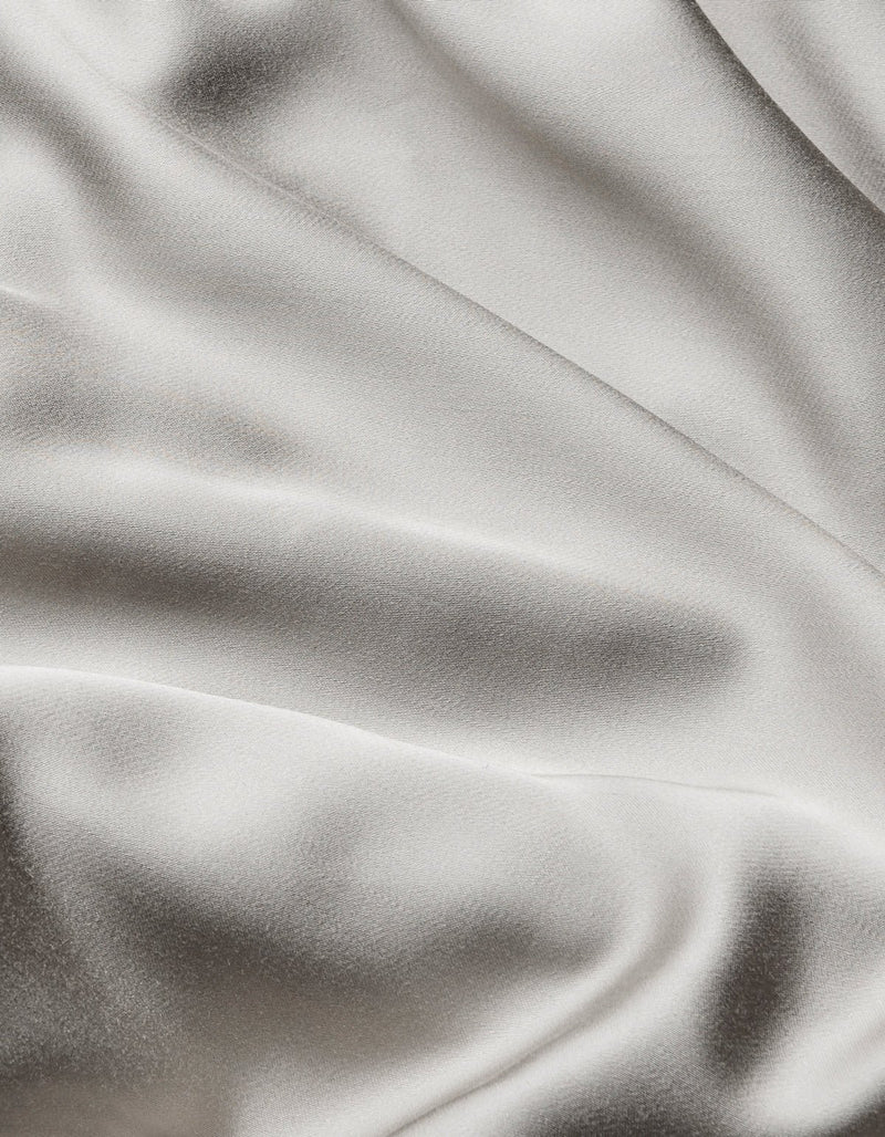 Close-up of Cozy Earth Bamboo Flat Sheet, featuring smooth, light-colored fabric with soft folds and gentle shadows for a silky, luxurious look.