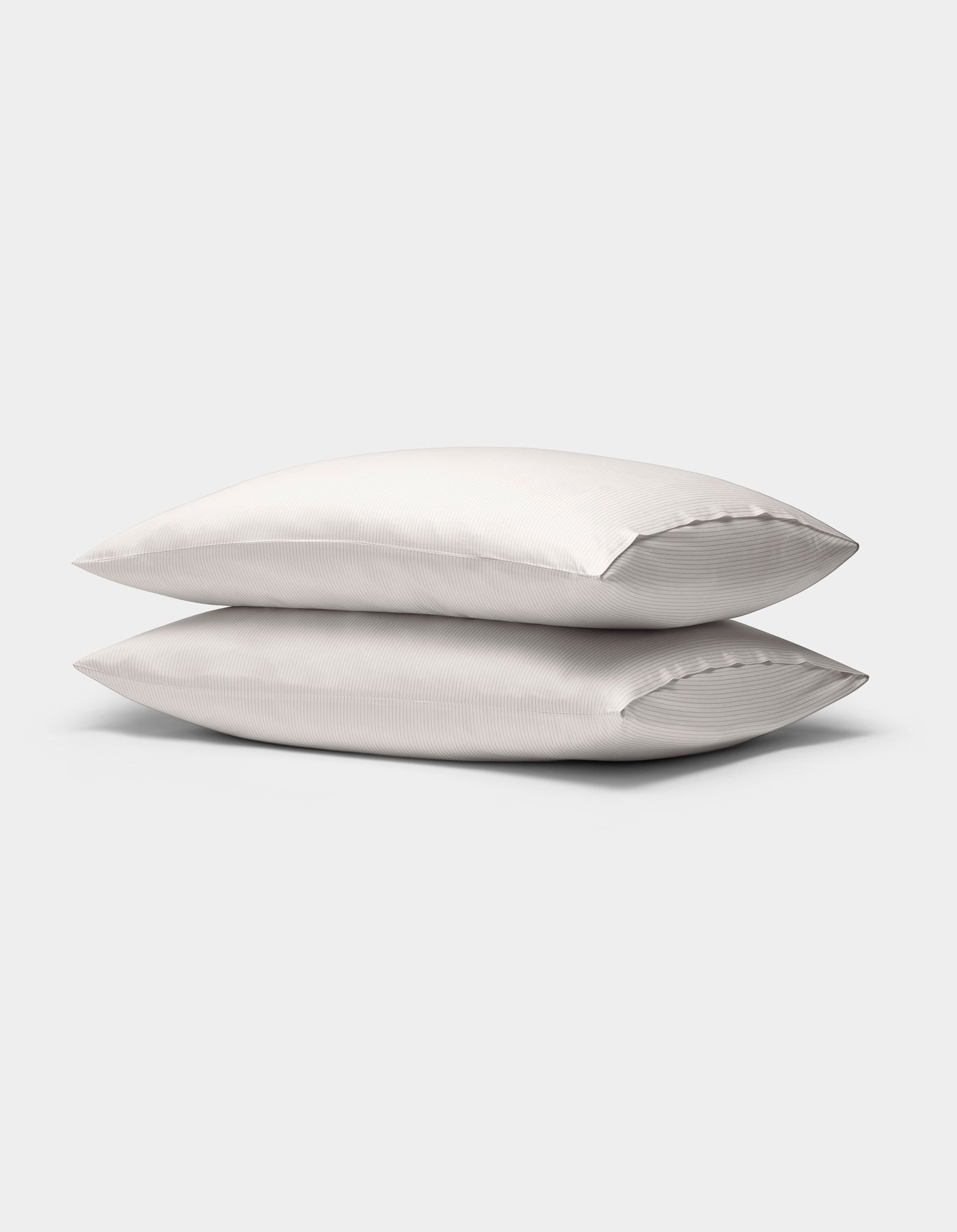 Two Cozy Earth Bamboo Pillowcases with subtle stripes are stacked together against a plain light gray background.|Color:Driftwood Pinstripe
