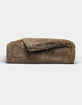The Cozy Earth Cuddle Blanket, featuring a plush brown fabric and soft, fuzzy texture, is shown folded against a plain white background.|Color:Walnut