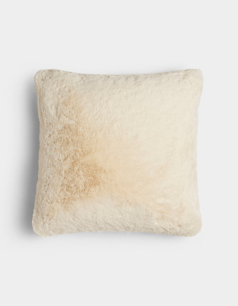 The Cuddle Pillow by Cozy Earth is a square, cream-colored, fluffy pillow featuring a light tan stain on the left side, shown against a plain white background.