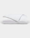 The Bamboo Duvet Cover by Cozy Earth is neatly folded with one corner flipped over, showcased against a plain light background.|Color:White