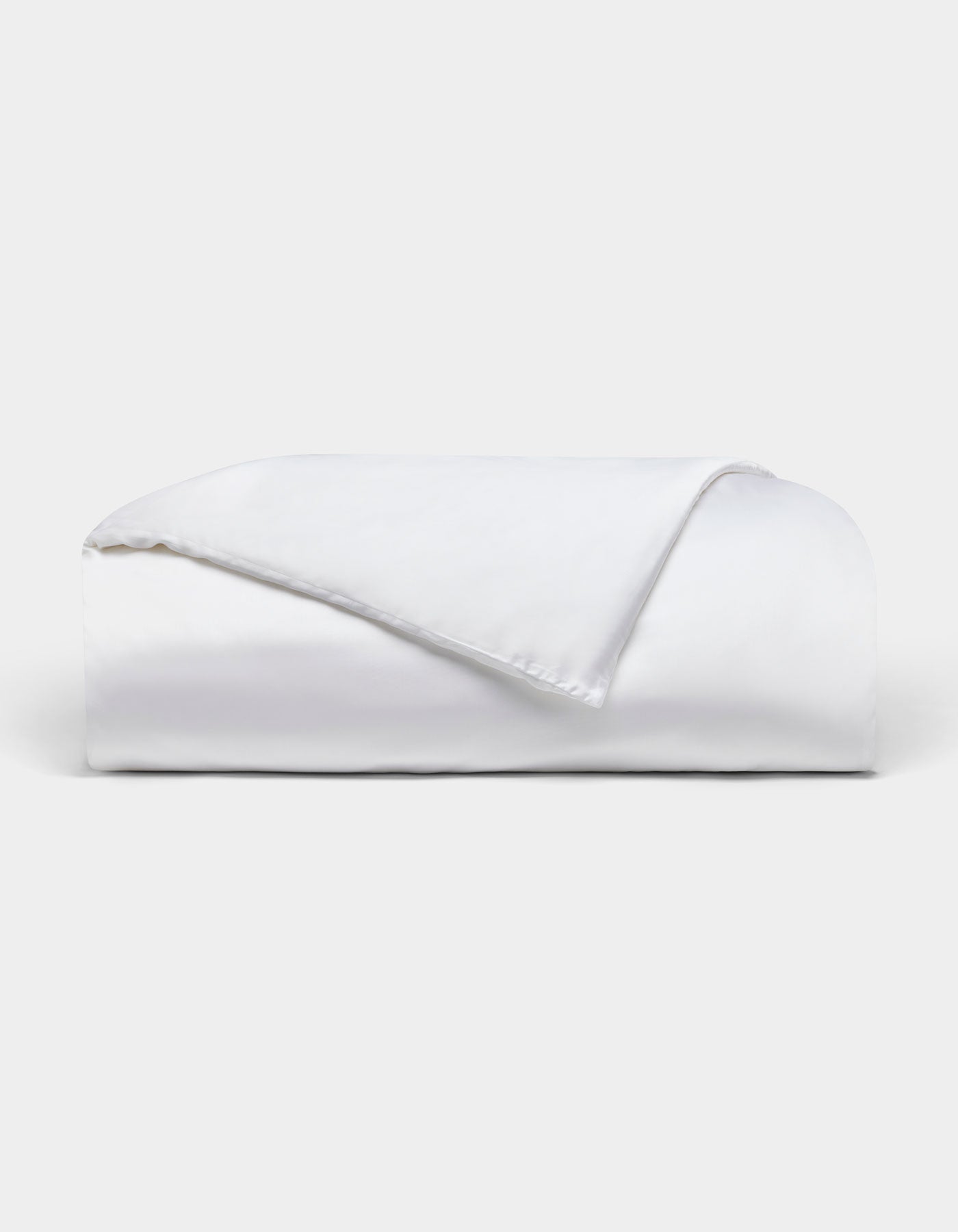The Bamboo Duvet Cover by Cozy Earth is neatly folded with one corner flipped over, showcased against a plain light background.|Color:White