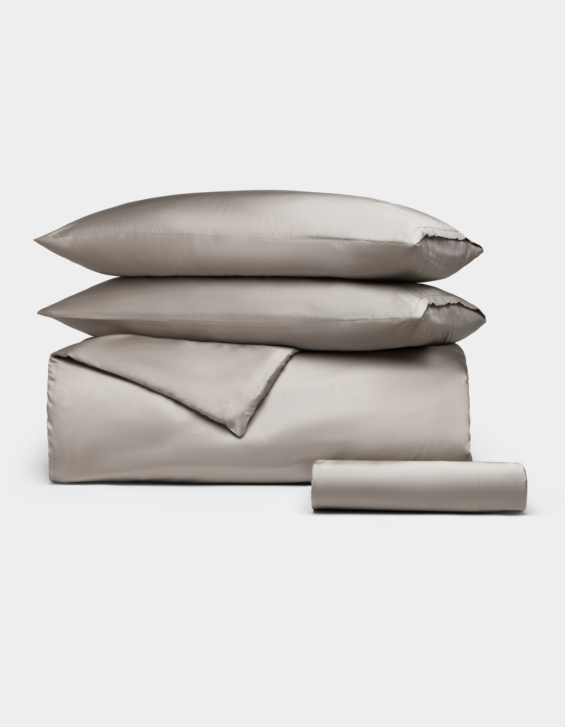 The Cozy Earth Bamboo Bedding Essential Bundle features neatly folded light gray bedding—a comforter, two stacked pillows, and a rolled sheet—displayed on a plain white background.|Color:Dove Grey