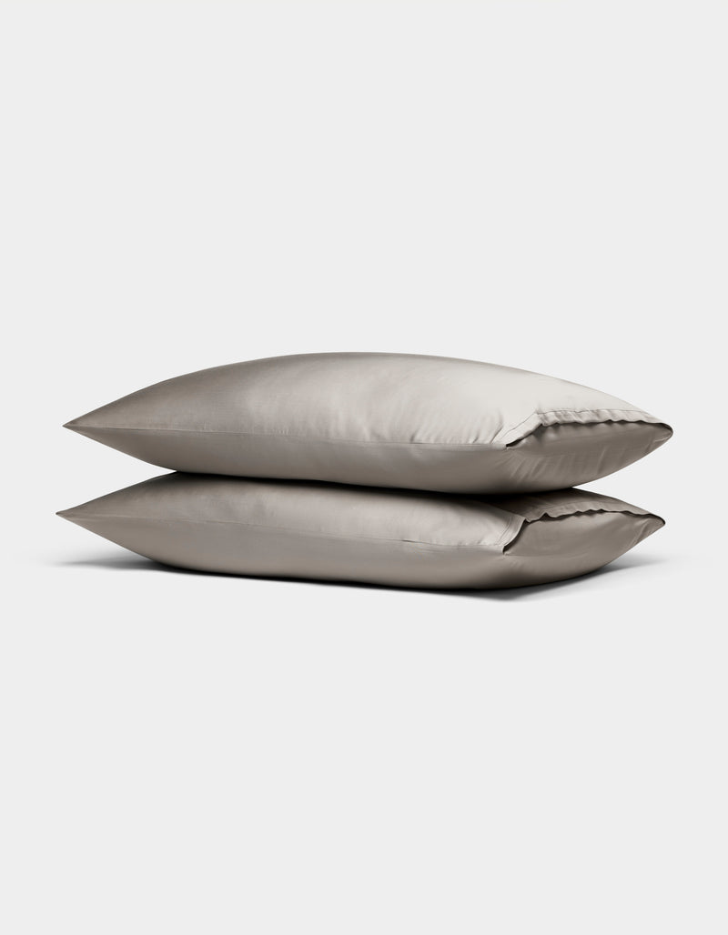 Two Cozy Earth Bamboo Pillowcases in light gray satin are stacked against a plain white background.