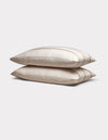Two Cozy Earth Bamboo Pillowcases in cream with subtle brown stripes are stacked neatly on a plain light gray background.|Color:Baja Stripe in Maple
