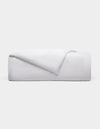 The Cozy Earth Linen Duvet Cover, neatly folded with one corner turned down, is displayed against a plain light gray background.|Color:White