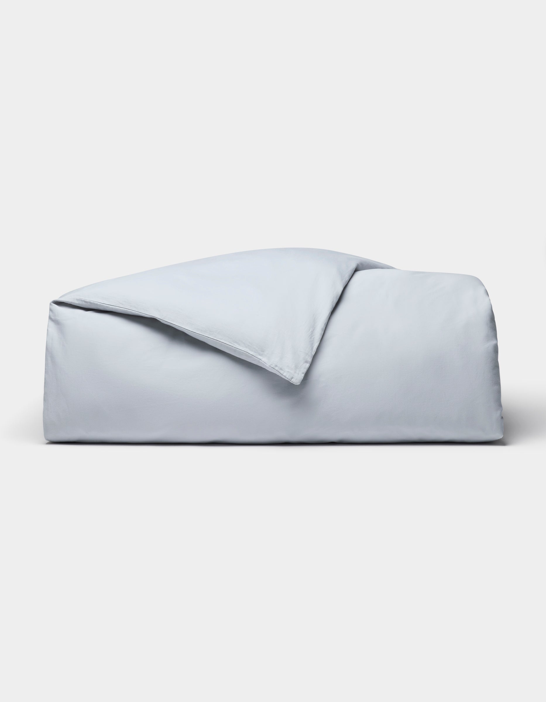 The Cozy Earth Soft-Wash Cotton Duvet Cover set, in light blue, is neatly folded and displayed against a plain white background.