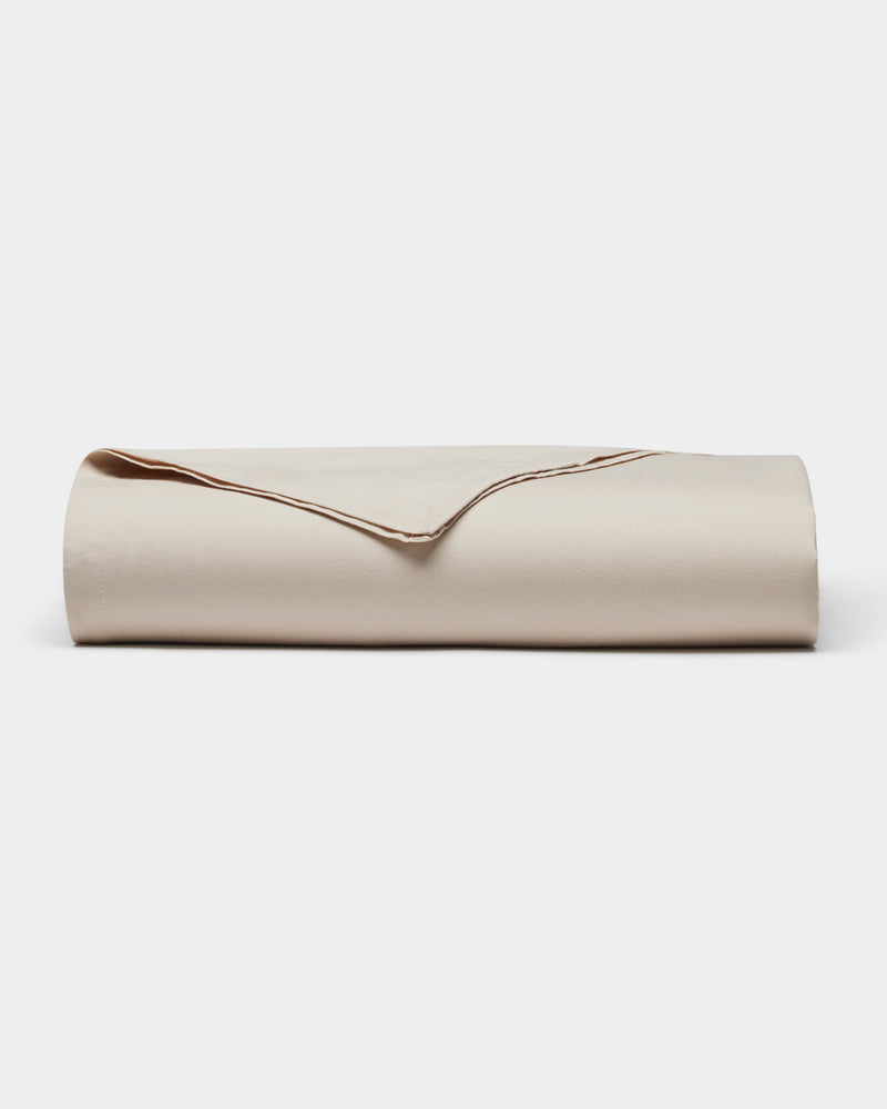 The Cozy Earth Soft-Wash Cotton Flat Sheet, neatly folded with one corner turned over to display its smooth texture and edges, is shown against a plain white background.