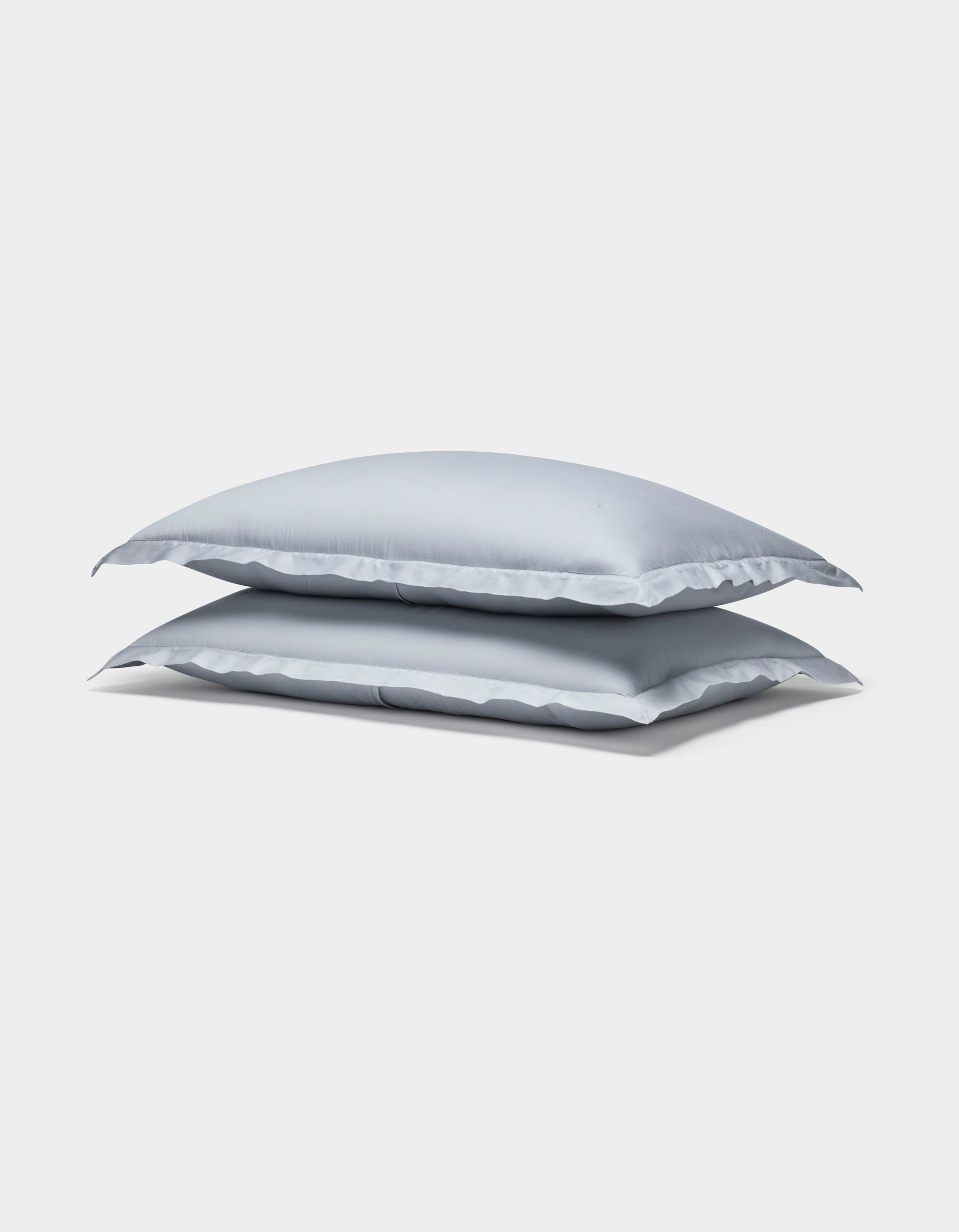 Two Cozy Earth Soft-Wash Cotton Quilted Shams in light gray are stacked neatly against a plain white background.