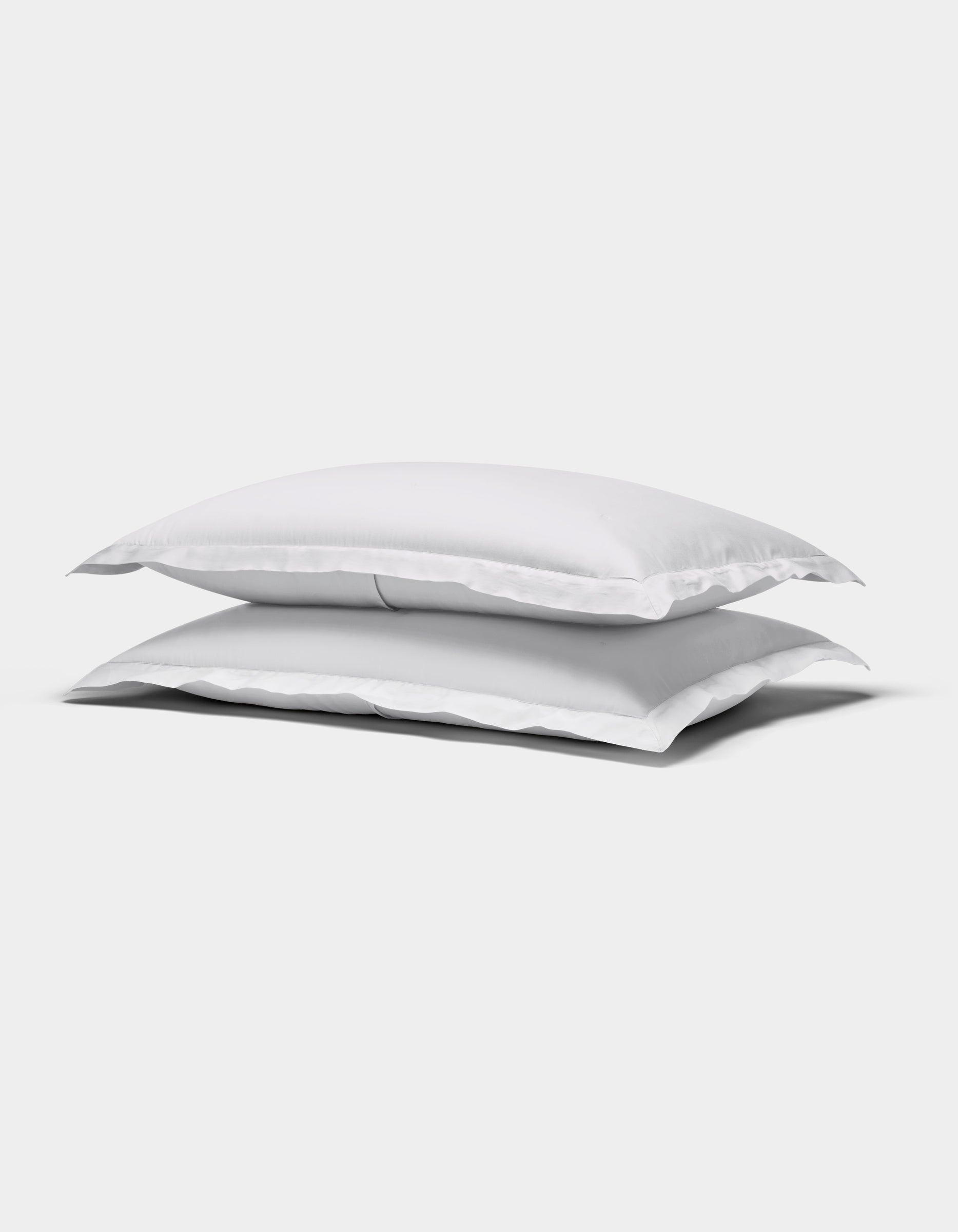 Two Cozy Earth Soft-Wash Cotton Quilted Shams, rectangular and white, are stacked atop each other against a plain white background.