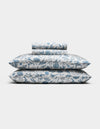 The Cozy Earth Bamboo Sheet Set, featuring pillowcases and sheets with a blue floral pattern on a white background, is neatly folded and displayed against a plain white backdrop.|Color:Winter Toile Pacific