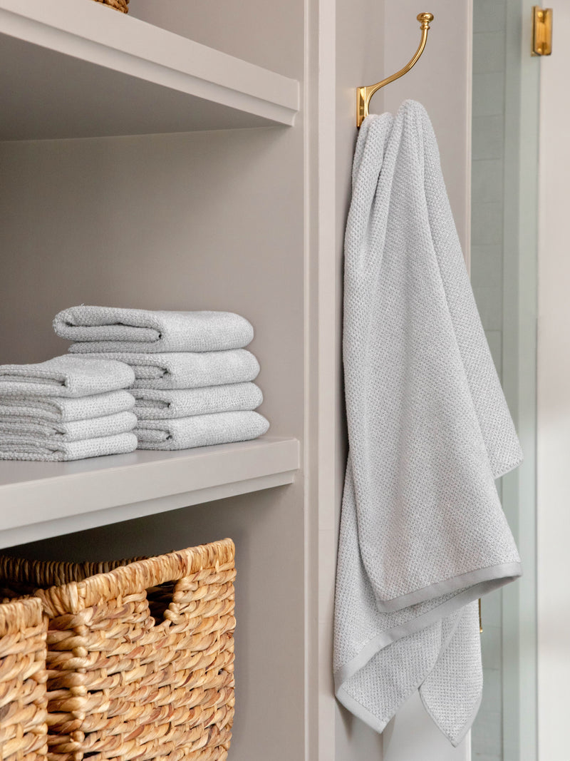 Complete Nantucket Bath Bundle in the color Heathered Harbor Mist. Photo of Complete Nantucket Bath Bundle taken as the hand towels, wash clothes, and bath towels are neatly placed on shelves in a bathroom.