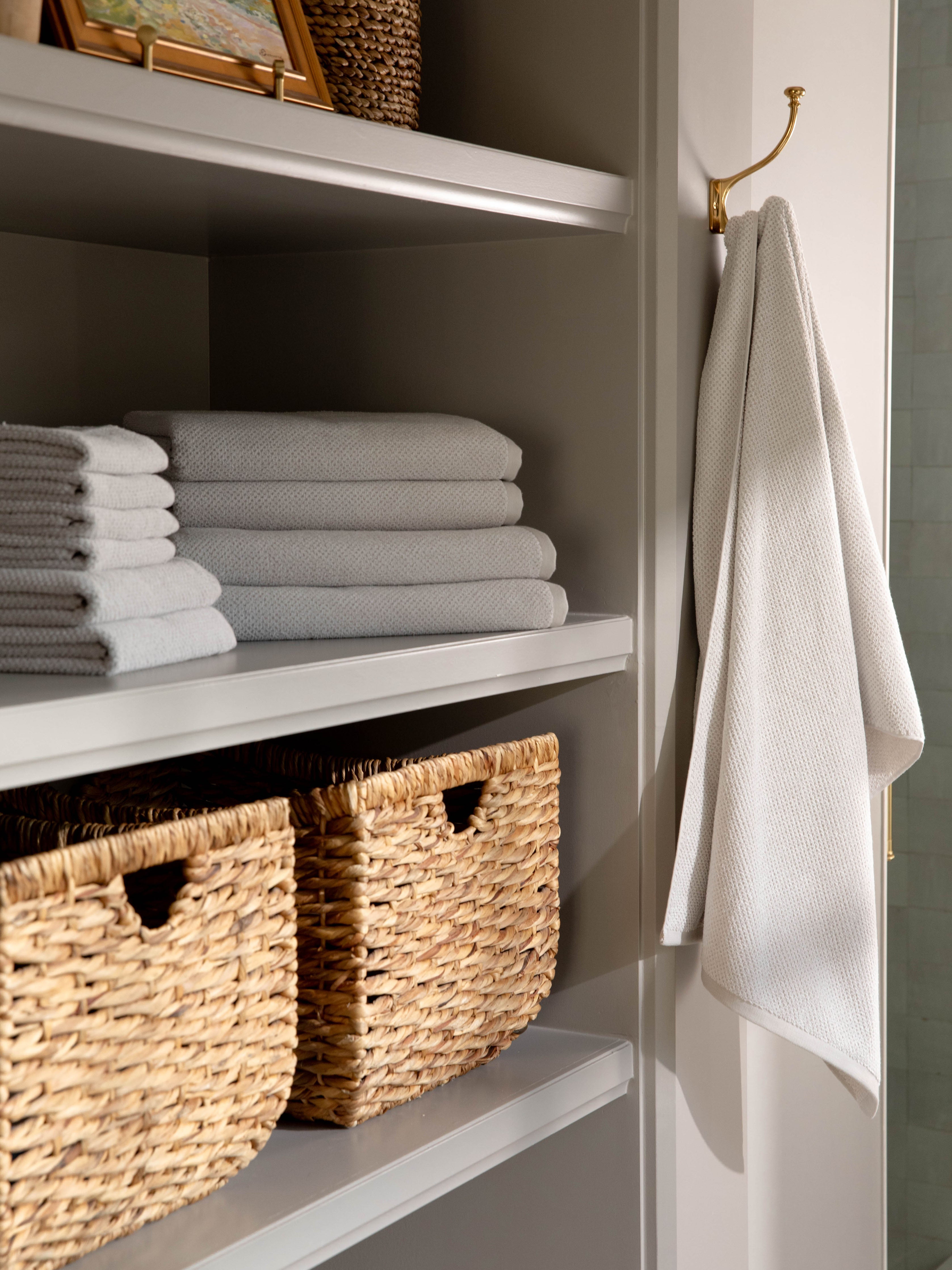 Complete Nantucket Bath Bundle in the color Heathered Light Grey. Photo of Complete Nantucket Bath Bundle taken as the towels rest on a shelf in a bathroom. |Color: Heathered Light Grey
