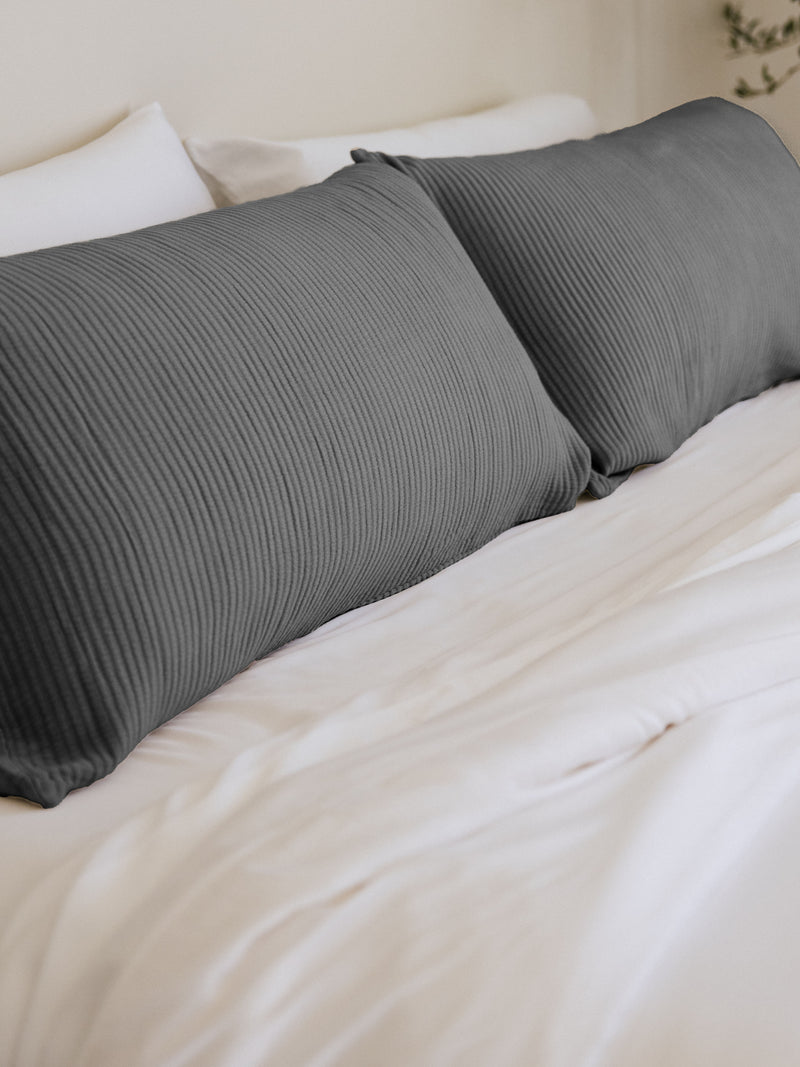 Charcoal coverlet shams on white bed