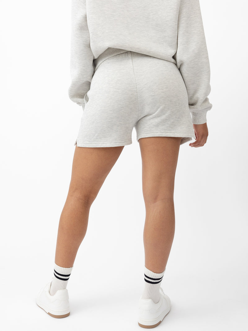 Heather Grey CityScape Shorts. The shorts are being worn by a female model in skate shoes. The background it a white background.