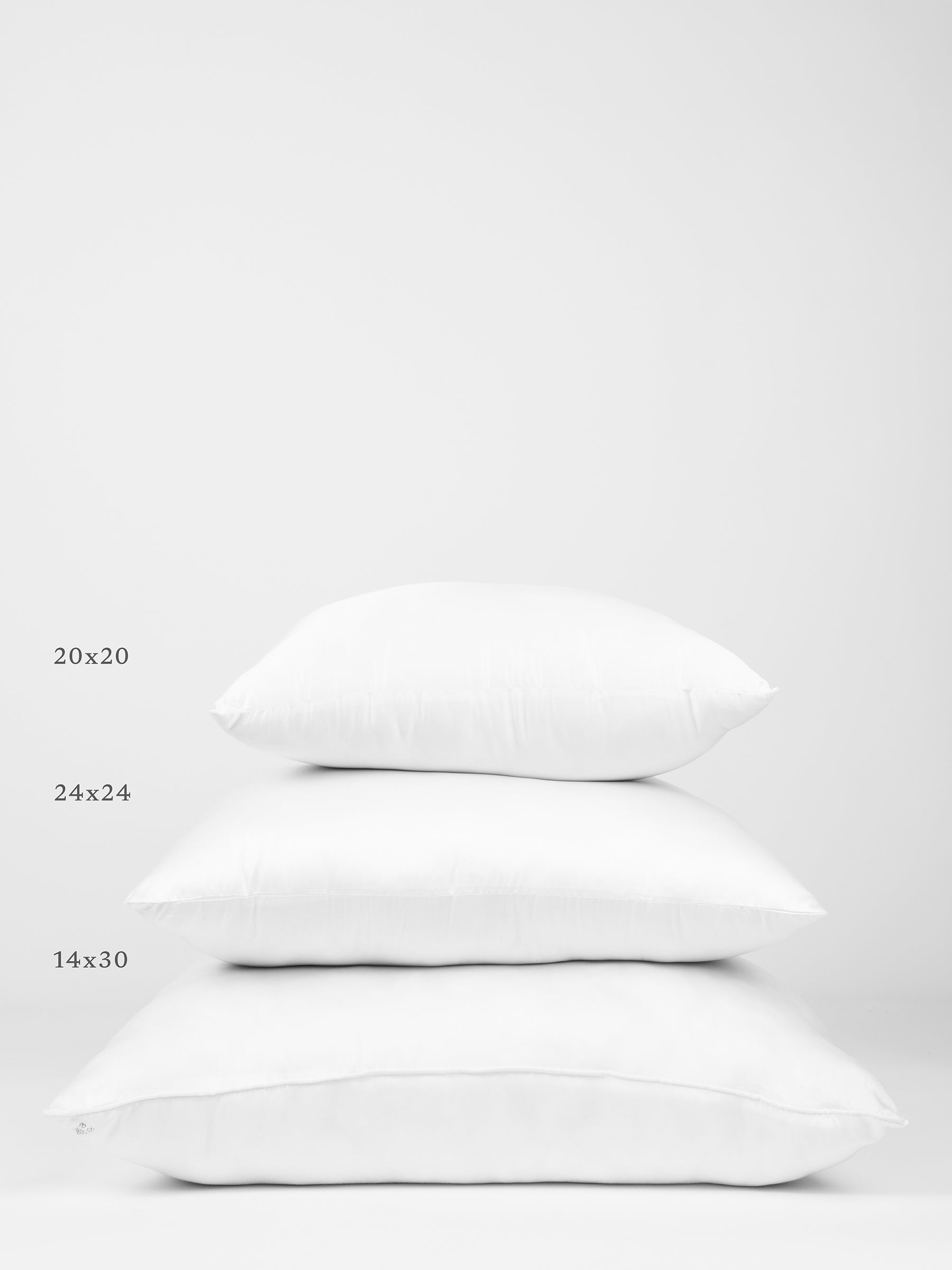 A white background with three white pillows stacked vertically. The top pillow, labeled 20x20, the middle pillow, labeled 24x24, and the bottom pillow, labeled 14x30, all showcase different sizes of the Cozy Earth Premium Down Alternative Insert. 