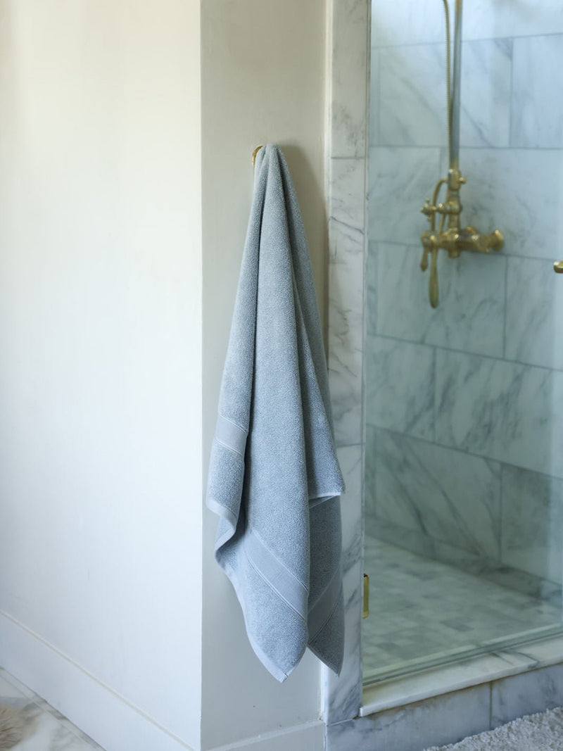 Harbor mist luxe bath towel hanging next to shower