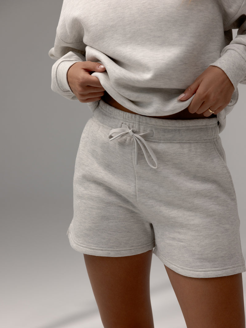 Heather Grey CityScape Shorts. The shorts are being worn by a female model. The background it a grey hue background.
