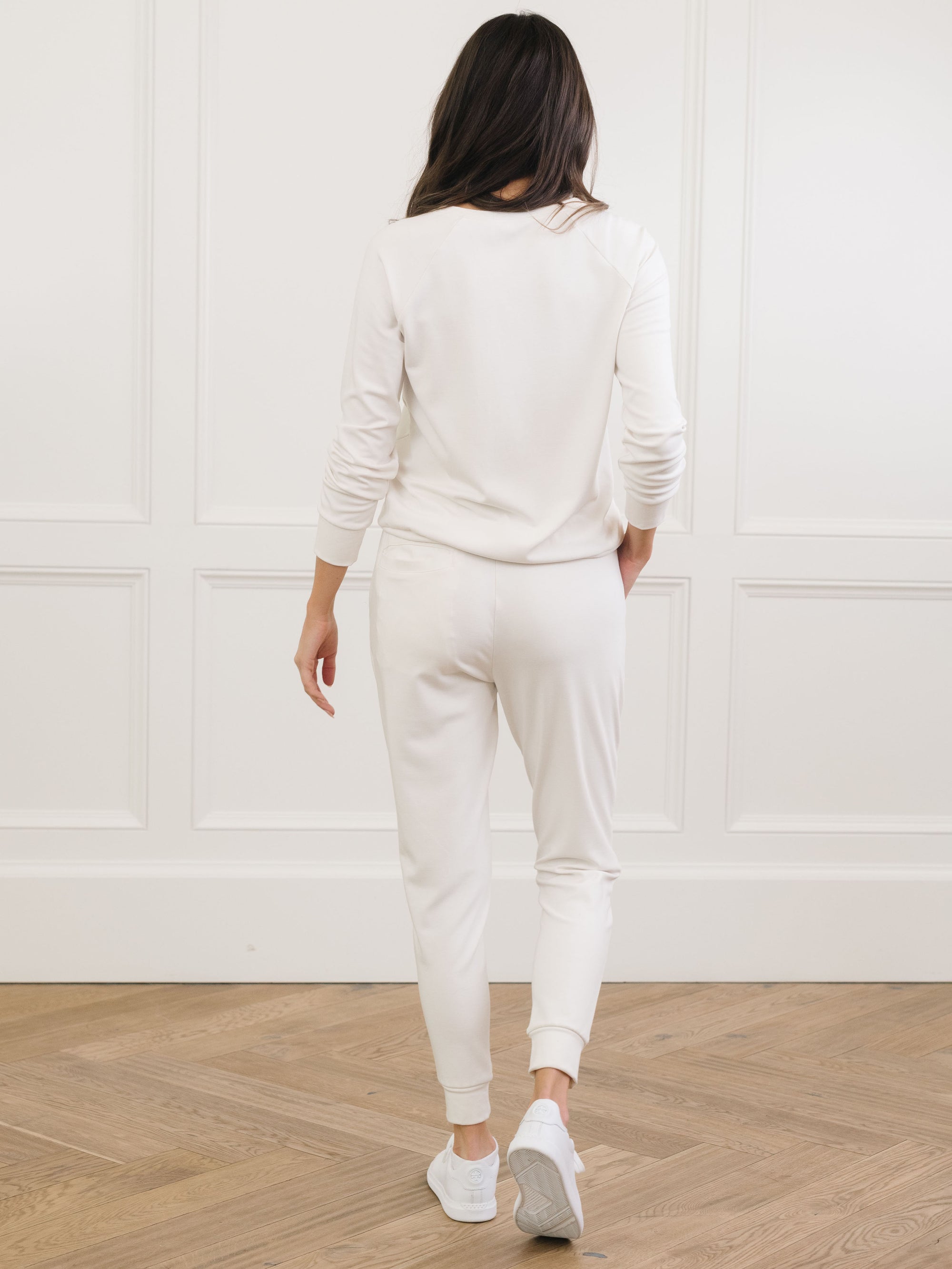Ivory Bamboo Jogger Set modeled by a woman. The photo was taken in a high contrast setting, showing off the colors and lines of the pajamas. 
