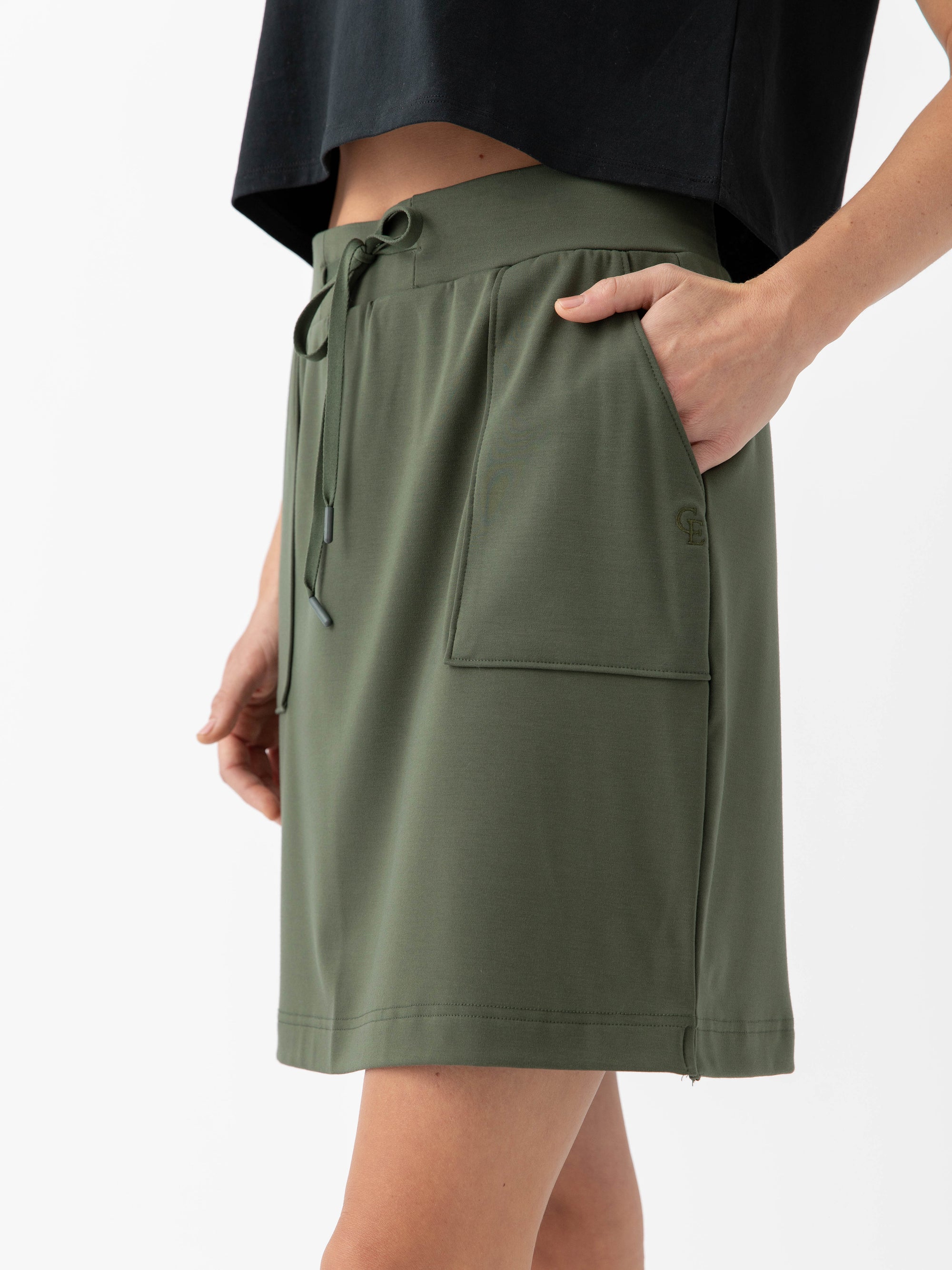 Person wearing a Cozy Earth Brushed Bamboo Patch Pocket Skirt in green on a white background 