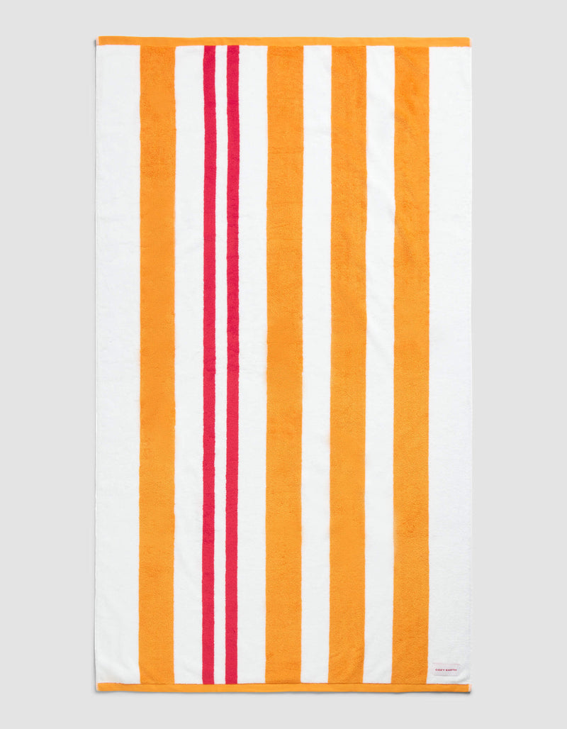 The Cozy Earth Classic Stripe Resort Towel in Picante Stripe features a rectangular design with vertical orange, red, and white stripes—wide orange and white bands paired with two narrower red stripes near the left edge.