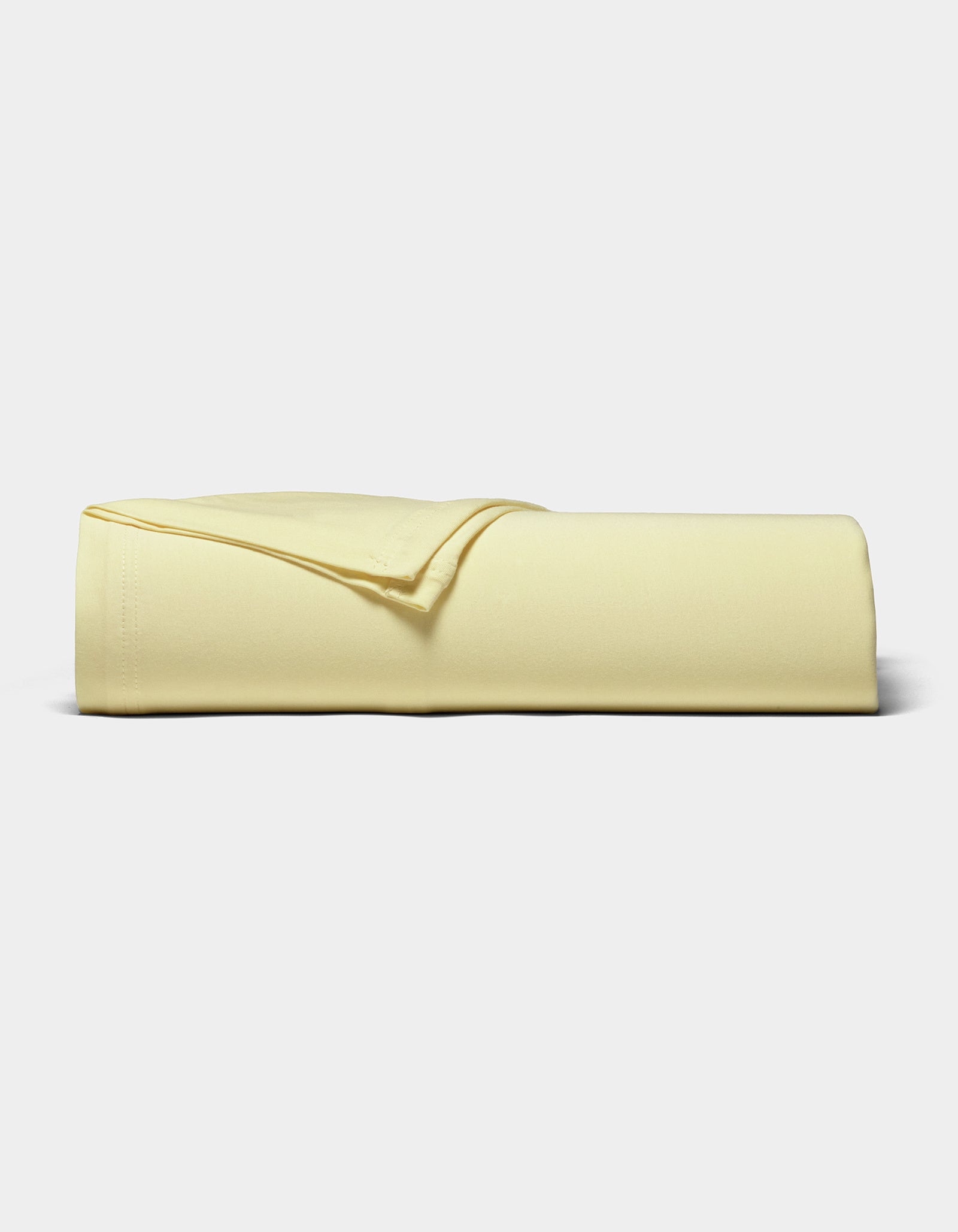 The Cozy Earth Bamboo Jersey Sheet Set, neatly folded in pale yellow, is displayed against a plain white background.|Color:Meringue