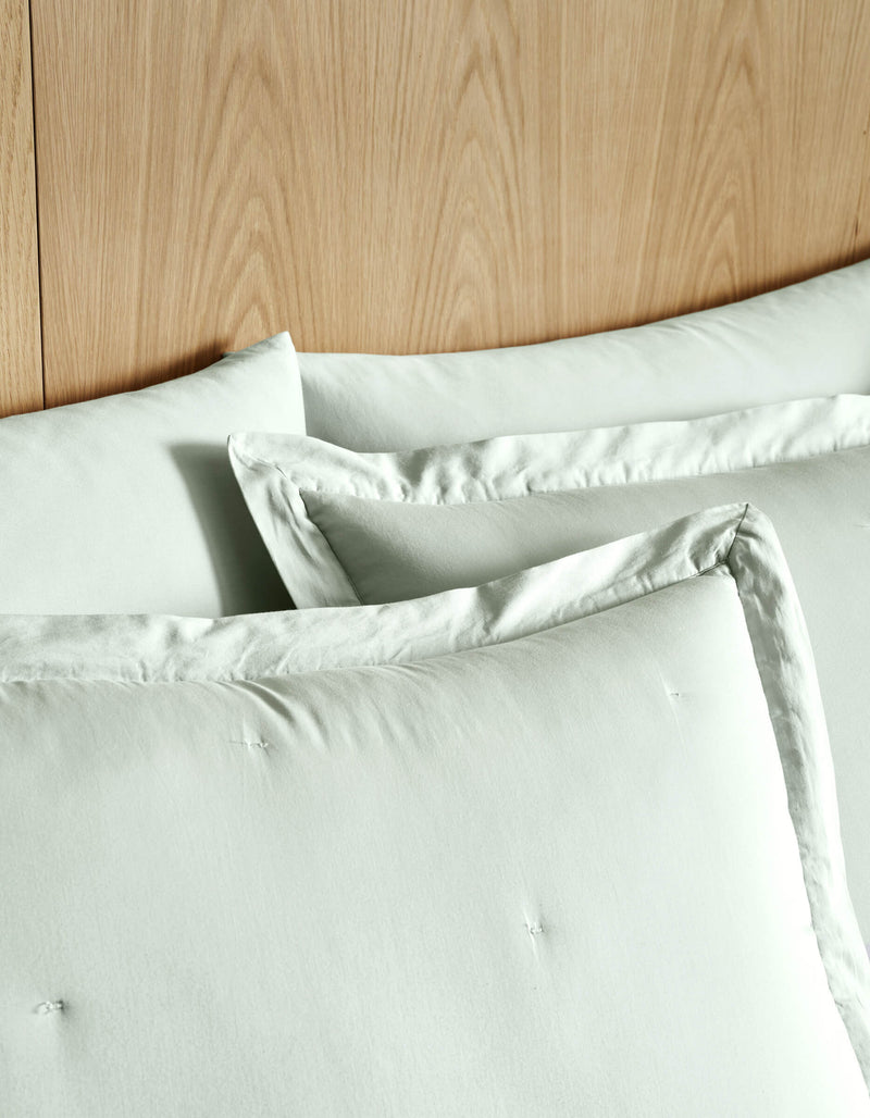 Two Soft-Wash Cotton Quilted Shams by Cozy Earth are neatly arranged against a wooden headboard, creating a clean and minimal bedding setup.