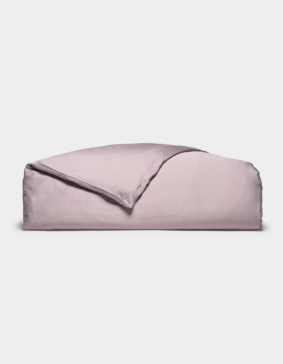 A neatly folded Cozy Earth Bamboo Duvet Cover in lavender, with one corner turned back, displayed against a plain white background.|Color:Lavender