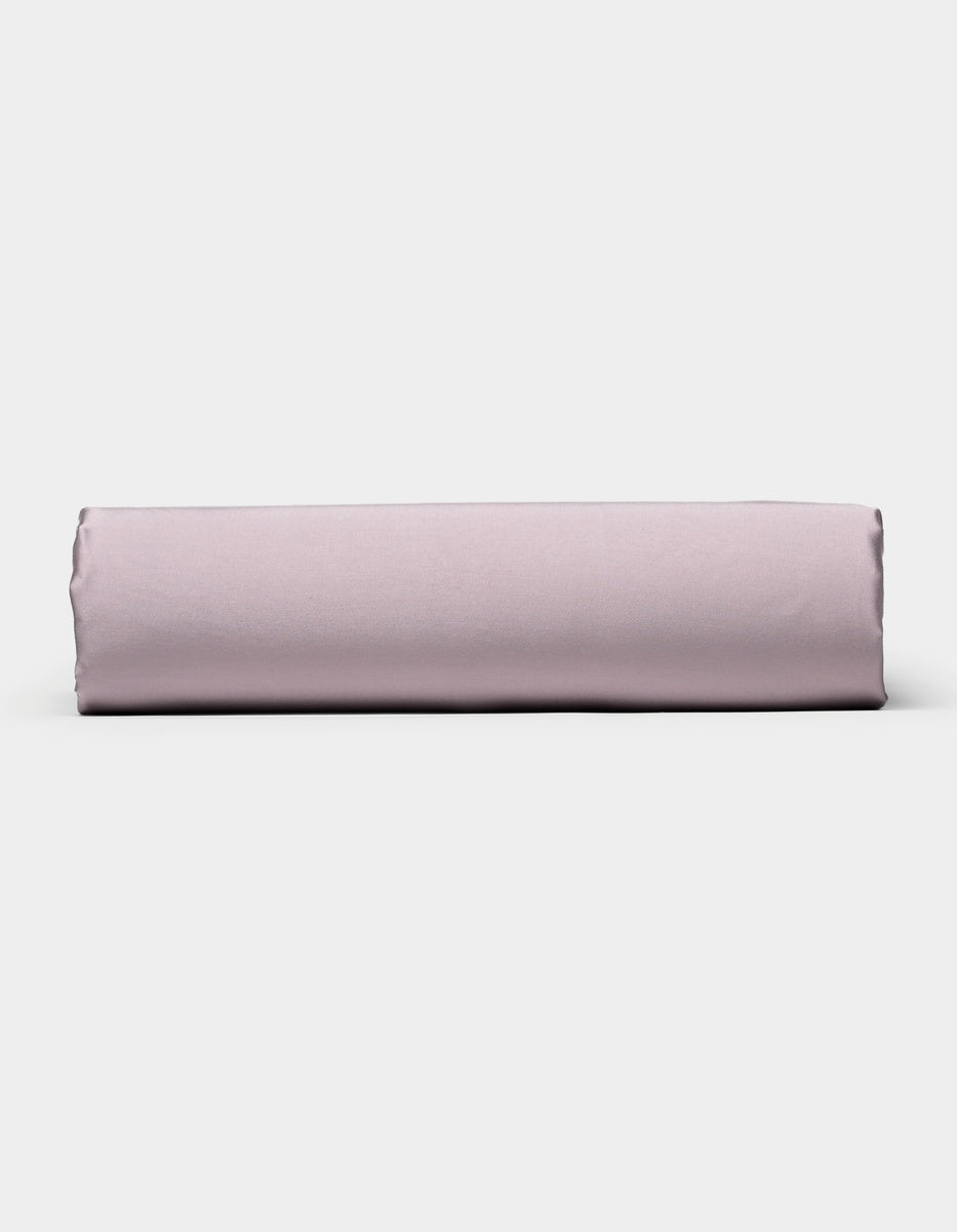 A neatly folded Cozy Earth Bamboo Fitted Sheet in light purple is positioned horizontally against a plain white background.|Color:Lavender