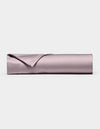 A neatly rolled, lavender-colored Bamboo Flat Sheet by Cozy Earth, with one corner folded over, displayed against a plain white background.|Color:Lavender
