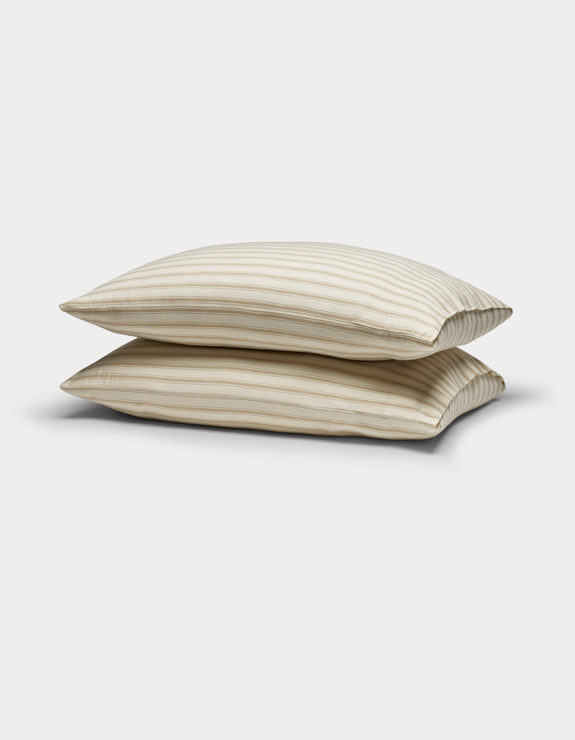 Two Cozy Earth Soft-Wash Cotton Pillowcases in beige with thin horizontal brown stripes are stacked against a plain white background.