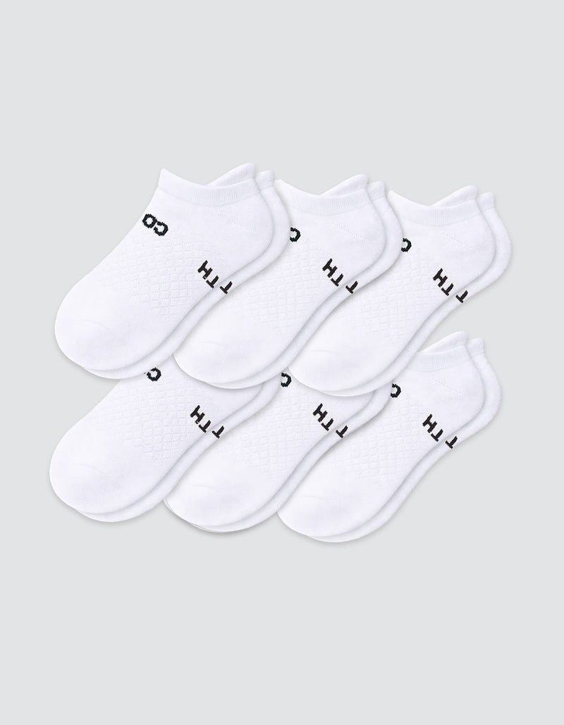 Six pairs of Cozy Earth Women's Essential Ankle Socks in white, featuring black text near the elastic opening, are arranged in two overlapping rows on a light gray background.