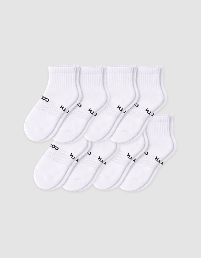 The Cozy Earth Men's Essential Quarter Sock 8-Pack features eight pairs of white socks with ribbed cuffs, neatly arranged in overlapping rows. Some have black text near the toe area, all displayed on a plain light background.