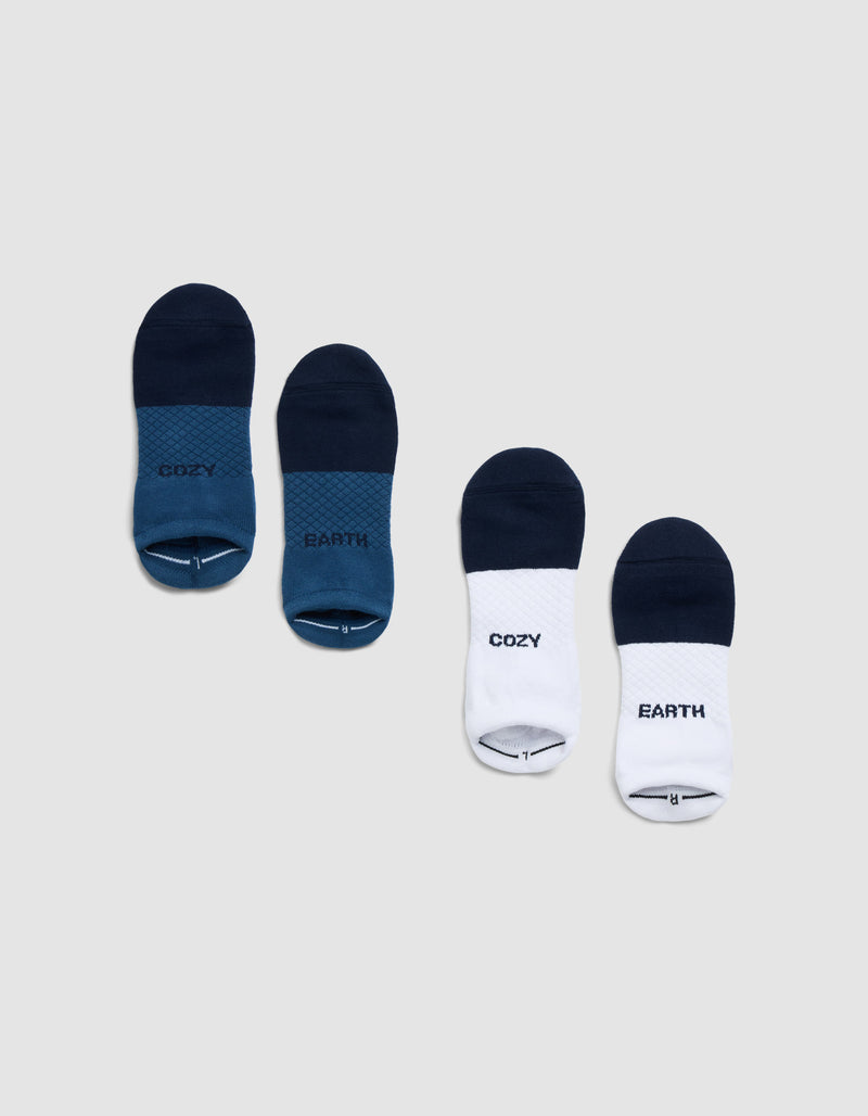Four pairs of Cozy Earth Essential Ankle Socks are displayed on a gray background: two blue pairs and two white-and-blue pairs, each featuring "COZY" and "EARTH" prints.