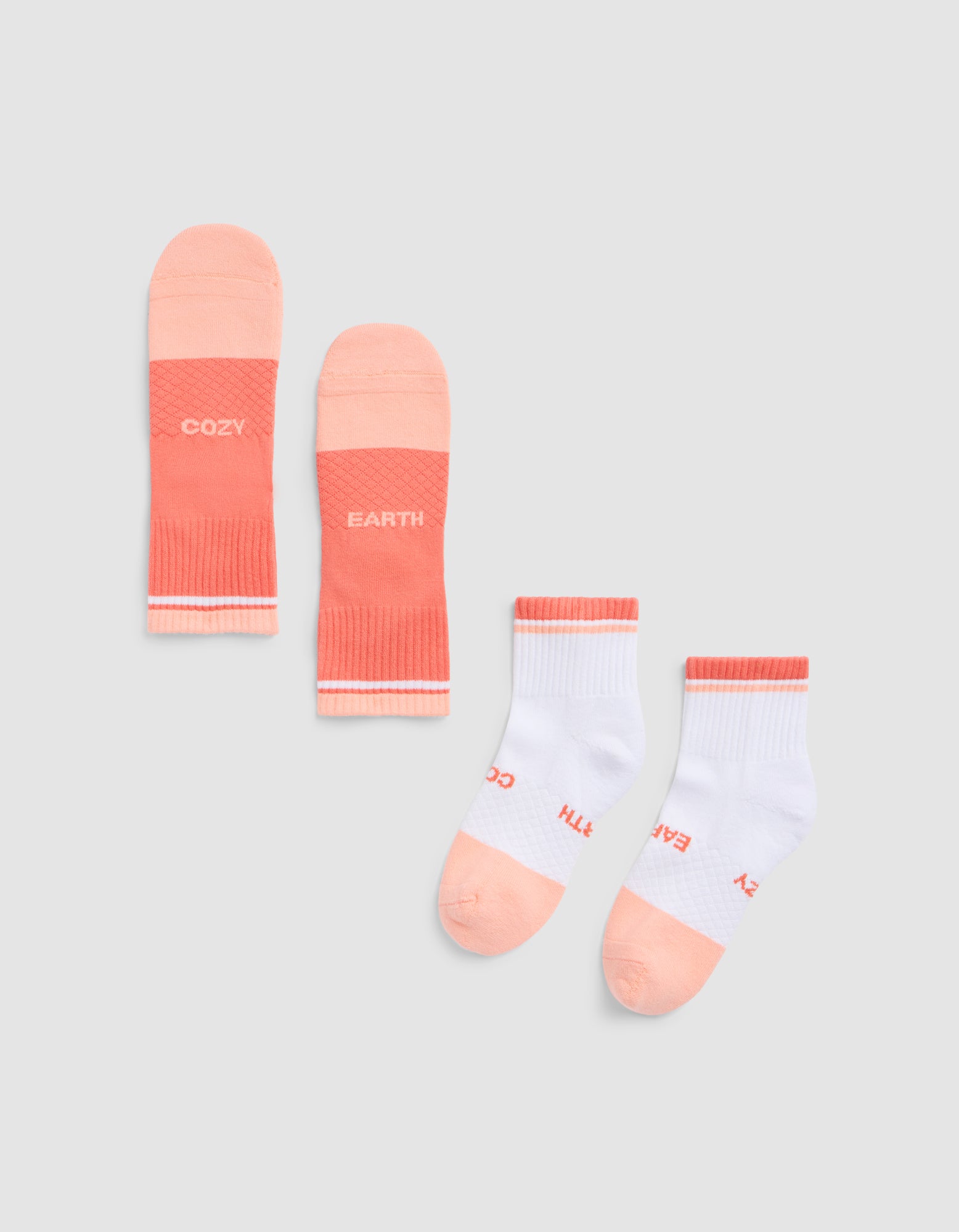 Two pairs of Cozy Earth Essential Quarter Socks: one solid coral with "COZY" and "EARTH" on each sock, and one white pair with coral accents and the same text near the toes, laid flat on a light gray background. |Color:Cantaloupe