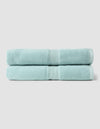 Two Luxe Bath Sheets by Cozy Earth, neatly folded and stacked, feature a light blue color against a plain, light gray background.|Color:Tide