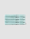 Four Luxe Washcloths by Cozy Earth, neatly folded in light blue, are stacked uniformly against a plain light gray background.|Color:Tide