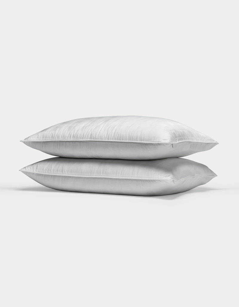 Two Cozy Earth Pillow Protectors are stacked together against a plain, light gray background.