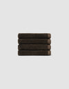 The Cozy Earth Complete Ribbed Terry Bath Bundle, featuring four dark brown towels, is arranged horizontally against a plain light gray background.|Color:Espresso