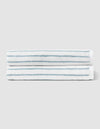 Two Striped Luxe Bath Towels by Cozy Earth, featuring thin blue stripes on white, are stacked together against a plain light gray background. |Color:Brook Stripe